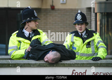 2 police officers arrest a drunk man in Reading town centre in the middle of the day Stock Photo