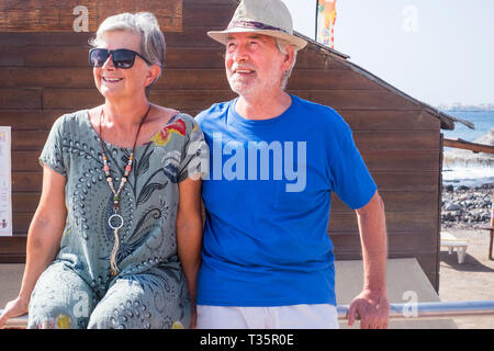 Senior couple in summer holday vacation together enjoying the outdoor leisure activity looking at the sun - together forever life for aged man and wom Stock Photo