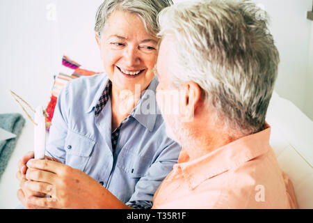 Nice beautiful caucasian senior woman cheerful smiling at  the man sitting with her - relationship and no limit age to flirt or be happy together - lo Stock Photo