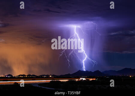 Lightning strikes a mountain as a monsoon thunderstorm moves across Tucson, Arizona Stock Photo