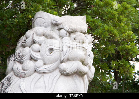 Close up picture of the head of a huge Komainu (dog-lion like guardian) stone statue at the Izanagi Shrine on Awaji Island in Japan Stock Photo