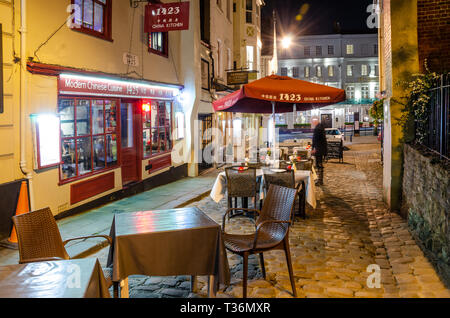 Table and chairs setup for outside dining in front of restaurants in Church Lane, Windsor, UK at night. Stock Photo