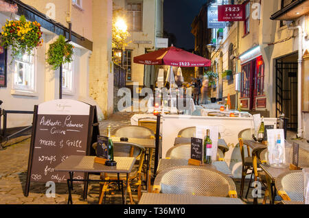 Table and chairs setup for outside dining in front of restaurants in Church Lane, Windsor, UK at night. Stock Photo