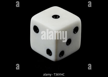 Close up of a white die on black background Stock Photo