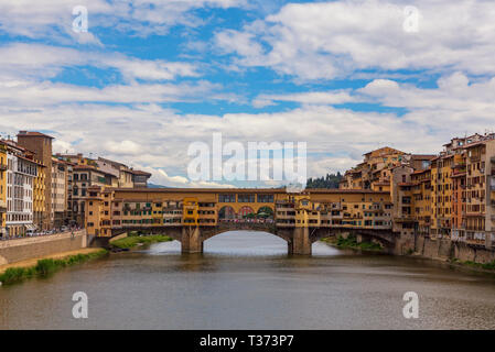 The Ponte Vecchio, a medieval stone closed-spandrel segmental arch bridge over the Arno River, in Florence, Italy, noted for still having shops built  Stock Photo