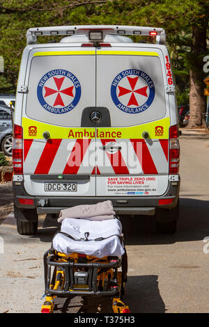 New South Wales ambulance at the beach with stretcher awaiting a patient being moved from the beach,Sydney,Australia Stock Photo