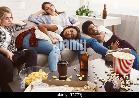 Friends suffering from stomachache and headache in messy room Stock Photo