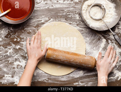 Chef rolling dough for pizza on table, top view Stock Photo
