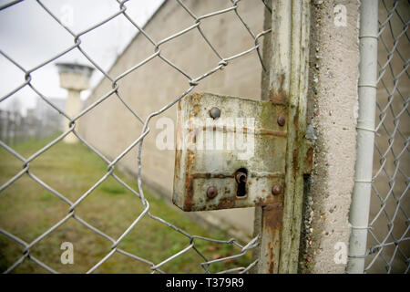 Locked gate in chain link fence, and watchtower in the perimeter of the Stasi HQ Hohenschonhausen complex, Berlin, Germany. Stock Photo