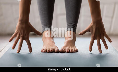 Woman practicing yoga, uttanasana pose, Head to knees close up Stock Photo