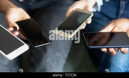 Male and female hands holding phones, close up view Stock Photo