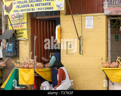 CUSCO, PERU- JUNE 20, 2016: a woman chops up chicken at a street side shop in cusco, peru Stock Photo