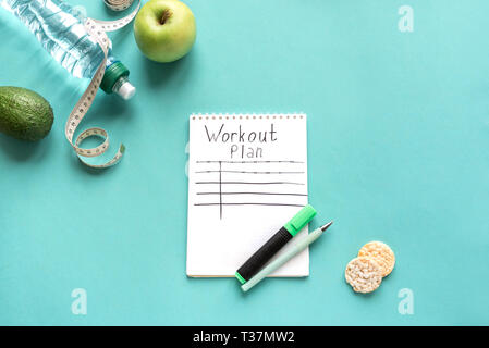 Workout plan mockup with water, fruits and measuring tape. Fitness, diet  and healthy lifestyle concept on blue, top view, copy space. Stock Photo