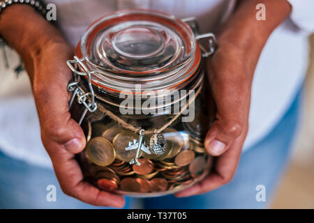 Middle age caucasian woman show her income to travel for the next vacation or adventure - european euro coin in a glass vase - home economy concept fo Stock Photo