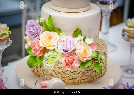 Big sweet multilevel wedding cake decorated with flowers. Concept of candy bar on party. Stock Photo