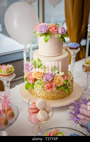 Big sweet multilevel wedding cake decorated with flowers. Concept of candy bar on party. Stock Photo