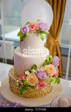 Big sweet multilevel wedding cake decorated with flowers. Concept of candy bar on party. Stock Photo
