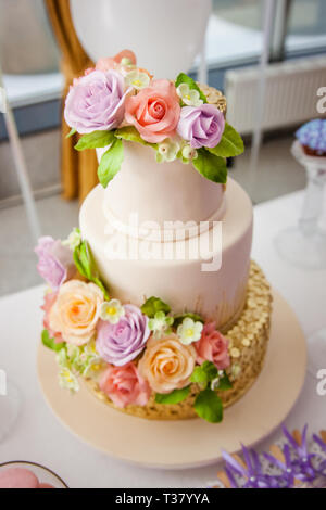 Big sweet multilevel wedding cake decorated with flowers. Concept of candy bar on party. Stock Photo
