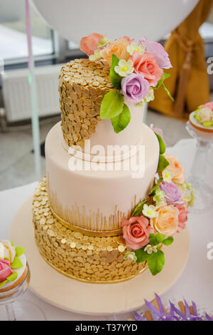 Big sweet multilevel wedding cake decorated with flowers. Concept of candy bar on party. Stock Photo