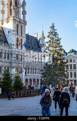 Brussels, Belgium - December 13, 2018: Tourists near The Brussels Town Hall with Christmas tree and market in front on the famous Grand Place in Bruss Stock Photo