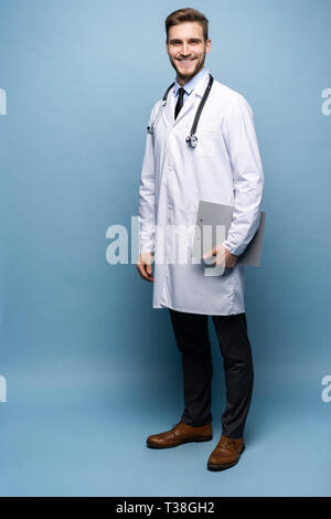Full length young medical doctor on blue background. Stock Photo