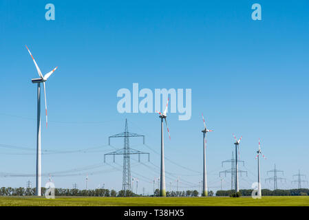 Wind energy plants and an overhead power line seen in Germany Stock Photo