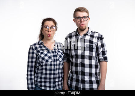 Nerds, bespectacled and funny people concept - funny couple in glasses are hugging on white background. Stock Photo