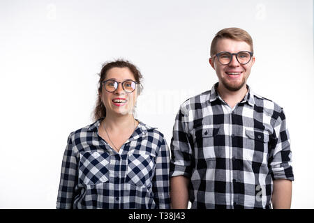 Nerds, bespectacled and funny people concept - funny couple in glasses are hugging on white background. Stock Photo