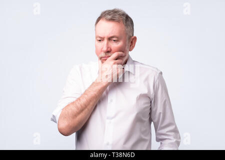 Senior european man thinking about his problems, expressing some doubts about decisions. Stock Photo