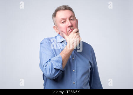 Senior european man thinking about his problems, expressing some doubts about decisions. Stock Photo