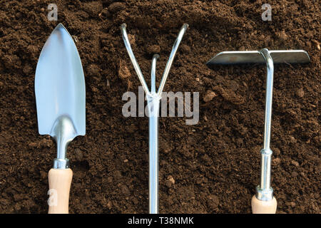 Gardening tools on soil background. Spring garden work concept Stock Photo