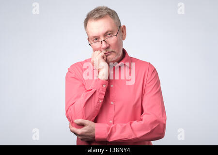 Senior european man thinking about his problems, expressing some doubts about decisions. Stock Photo