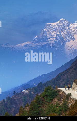 Two porters on the trail between Namche Bazaar and Dingboche in Nepal Stock Photo