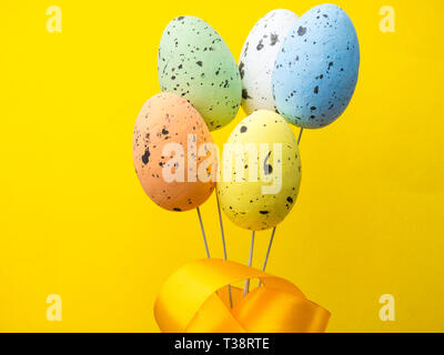 Easter holiday background. Pastel coloured decorated easter eggs on yellow background. copy space Stock Photo