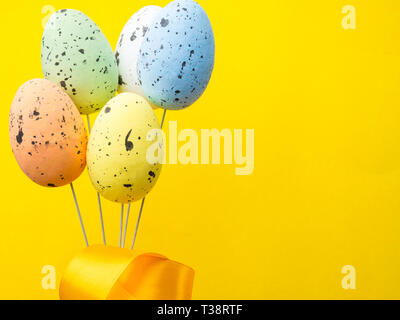 Easter holiday background. Pastel coloured decorated easter eggs on yellow background. copy space Stock Photo