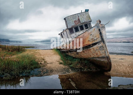 An old wrecked fishing boat grounded on a shingle beach in Kent under a ...