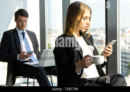 Young workers having break at office and resting near window Stock Photo