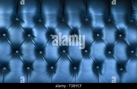 Background texture of dark indigo blue capitone genuine leather, retro Chesterfield style soft tufted furniture upholstery with deep diamond pattern a Stock Photo