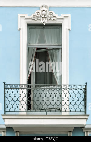 Rectangular window with a balcony against a blue wall. From the window series of St. Petersburg. Stock Photo