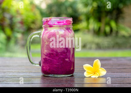 Fresh tropical smoothie with red dragon fruit, green avocado, yogurt and honey in glass mug for breakfast , close up. The concept of healthy eating, s Stock Photo