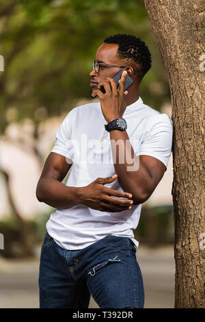 Outdoor portrait of a Young black African American young men talking  on mobile phone Stock Photo