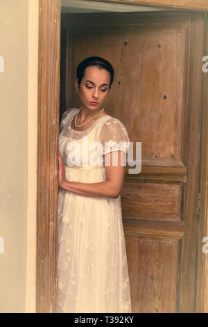 Young lady in authentic regency dress standing in a doorway Stock Photo