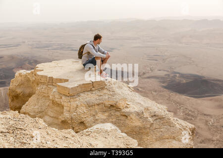 Mitzpe Ramon, Israel - 22 november, 2016: Man watching the horizon on the edge of Ramon crater cliff at  Negev desert, Israel Stock Photo