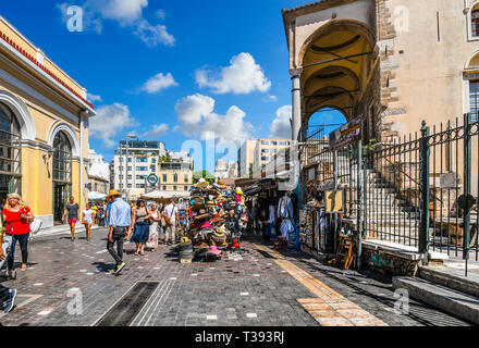 Tourists shop and sightsee the stores, marketplace and stalls selling gifts in the Monastiraki Square on a sunny day in Athens, Greece. Stock Photo