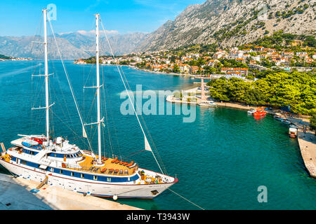 A sailing yacht is harbored on the Boka bay at the port of the medieval city of Kotor, Montenegro. Stock Photo