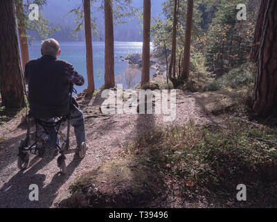 Old senior sitting alone on his walker Stock Photo