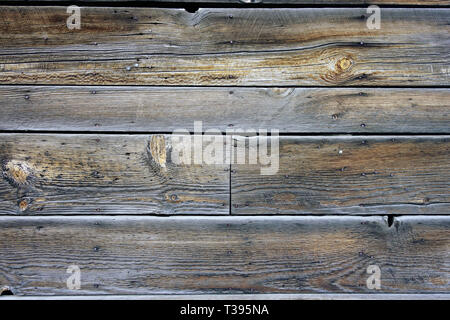 Old discolored wood siding on an exterior wall of a building. Stock Photo