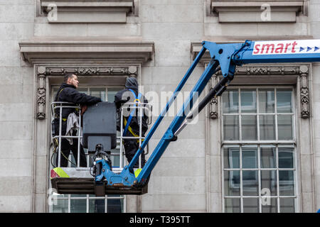 Workmen on a elevated platform attend to a building, Pall mall, London, Saturday, March 23, 2019.Photo: David Rowland / One-Image.com Stock Photo