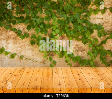 Empty wooden table over grunge wall Stock Photo