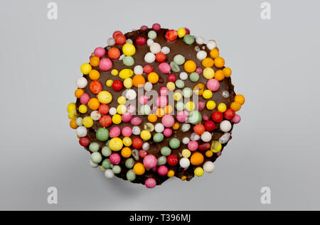 Macro image of a 'freckle', chocolate bud coated in sprinkles, isolated on a grey background Stock Photo